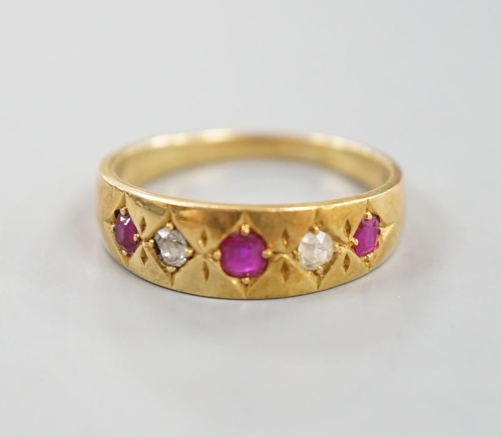 An early 20th century yellow metal and gypsy set three ruby and two stone diamond ring, size P, gross 4.3 grams.